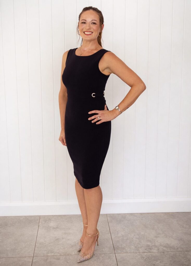 Home: Woman in stylish black dress and sparkly heels posing confidently. Fashionable and chic.