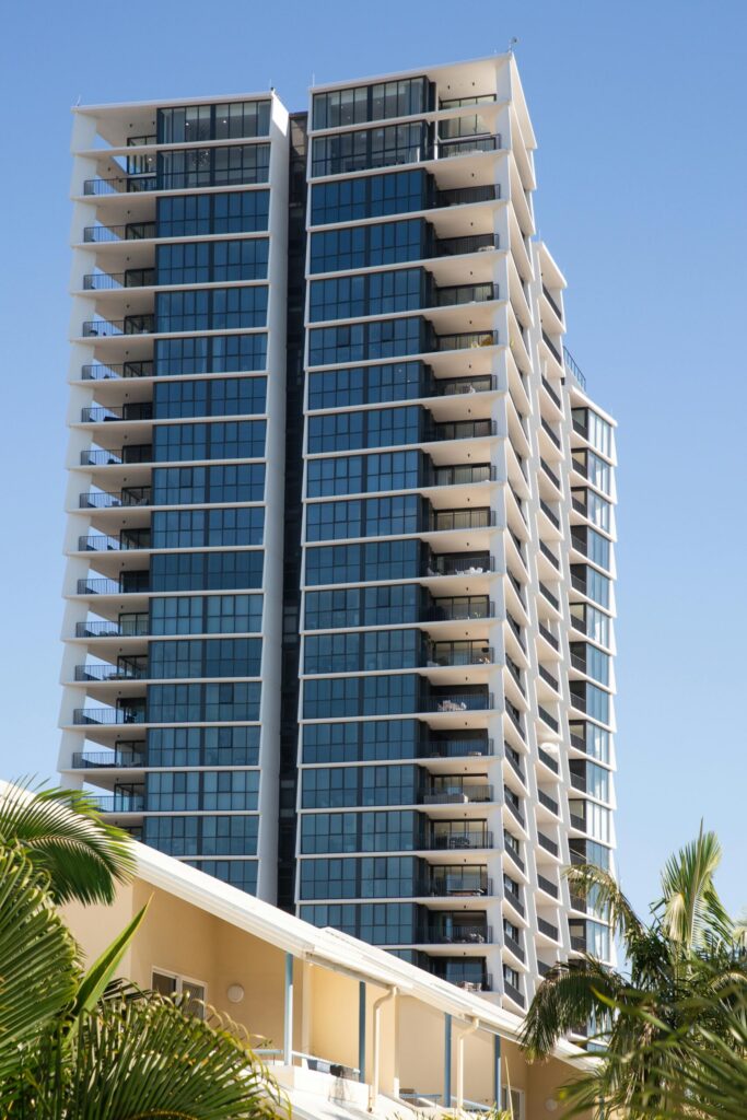 Gold Coast highrise building with balconies. Modern architecture, blue sky. About and services offered in the area.