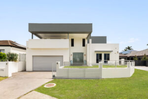 95 Bayswater Avenue, Varsity Lakes real estate. Modern white house with grey accents, gate, and lawn. Varsity Lakes property.